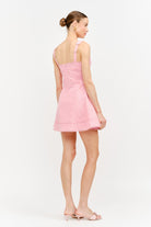 Woman wearing a pink dress on a white background
