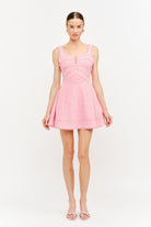 Woman wearing a pink dress on a white background