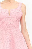 Close-up of a pink lace dress with a white background