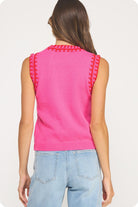 Person wearing a pink sleeveless top with textured shoulders on a white background