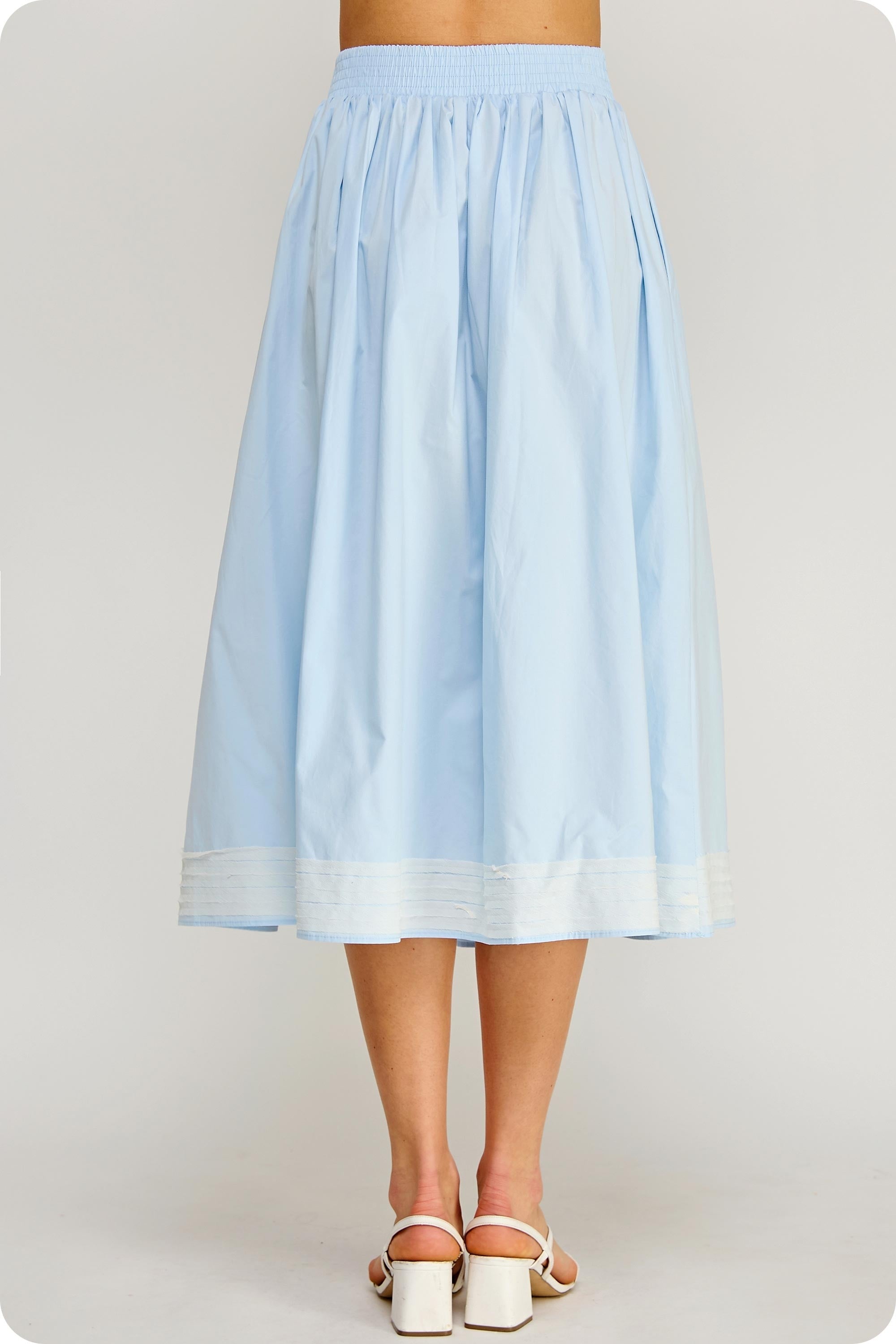 Light blue skirt worn by a person on a plain background