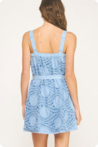 Woman wearing a light blue lace dress on a white background