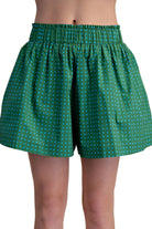 Green patterned shorts worn by a person on a beige background