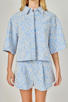 Person wearing a blue and white patterned outfit on a plain background