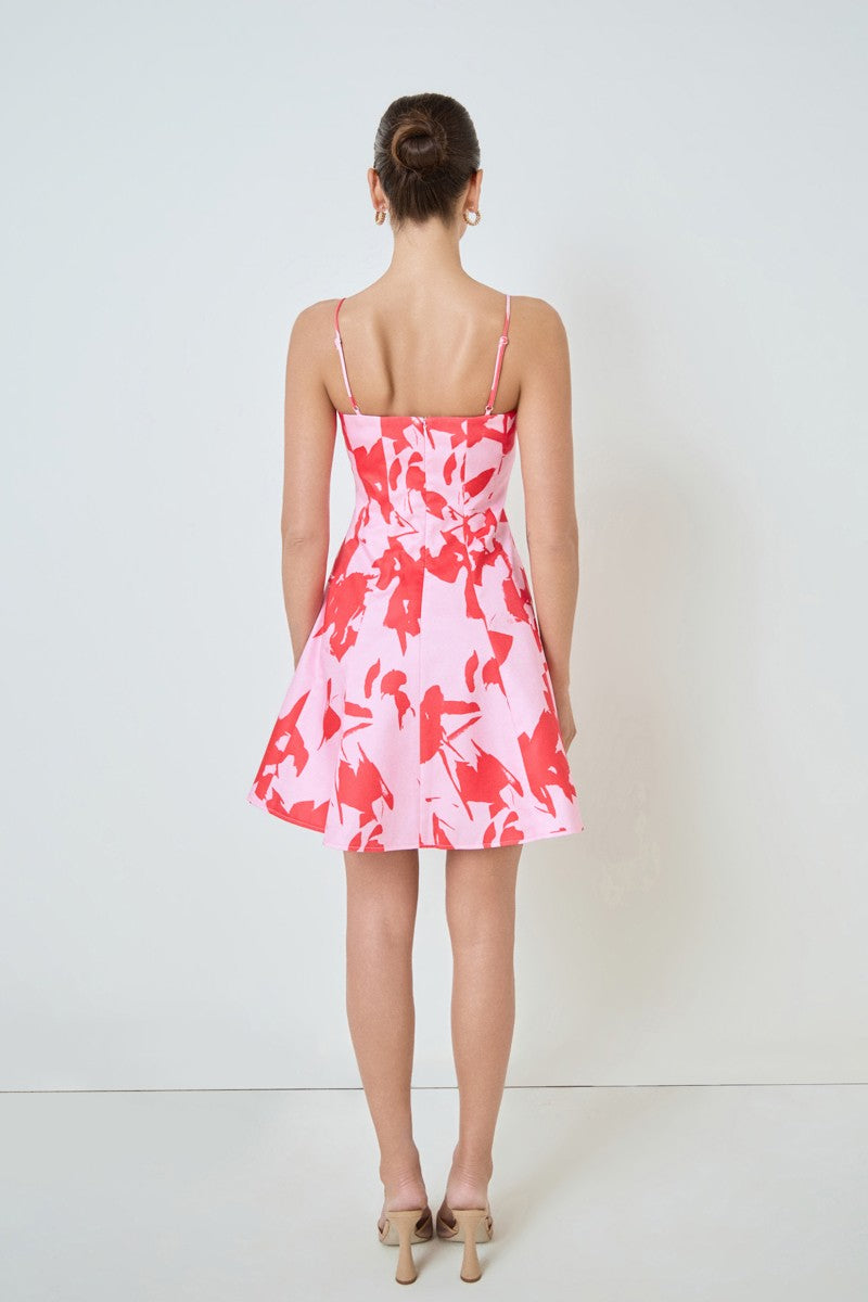 Woman wearing a pink and white patterned dress against a white background