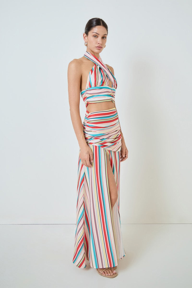 Woman wearing a colorful striped two-piece outfit on a white background