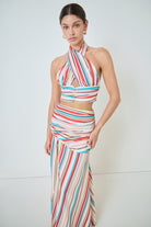 Woman wearing a colorful striped dress against a white background