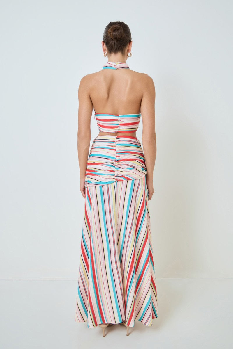 Woman wearing a colorful striped dress against a white background