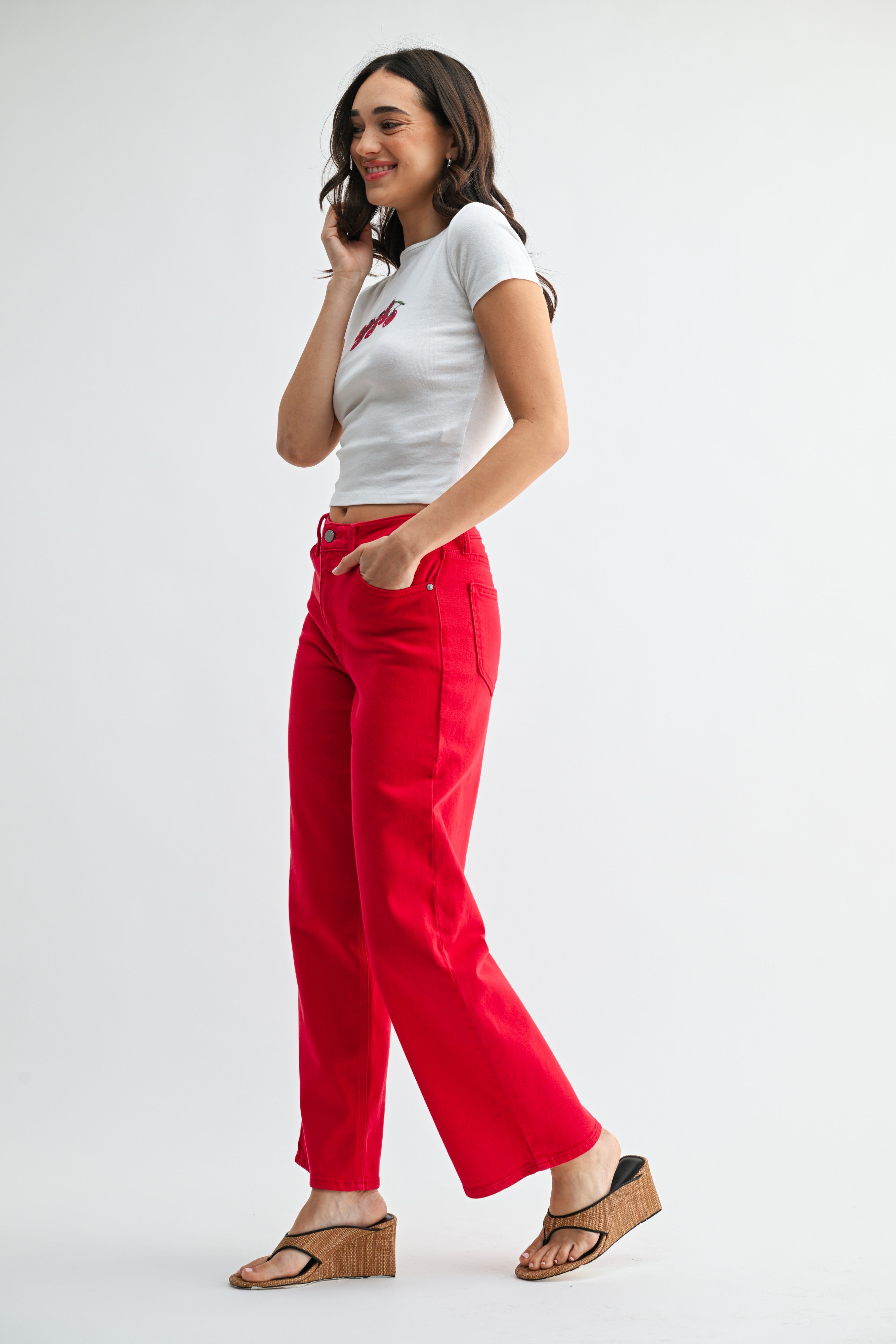Woman wearing a white t-shirt and red pants on a white background