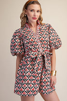 Woman wearing a patterned dress with puff sleeves on a beige background
