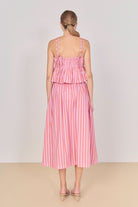 Woman wearing a pink and white striped dress on a plain background