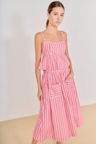 Woman wearing a pink and white striped dress against a plain background