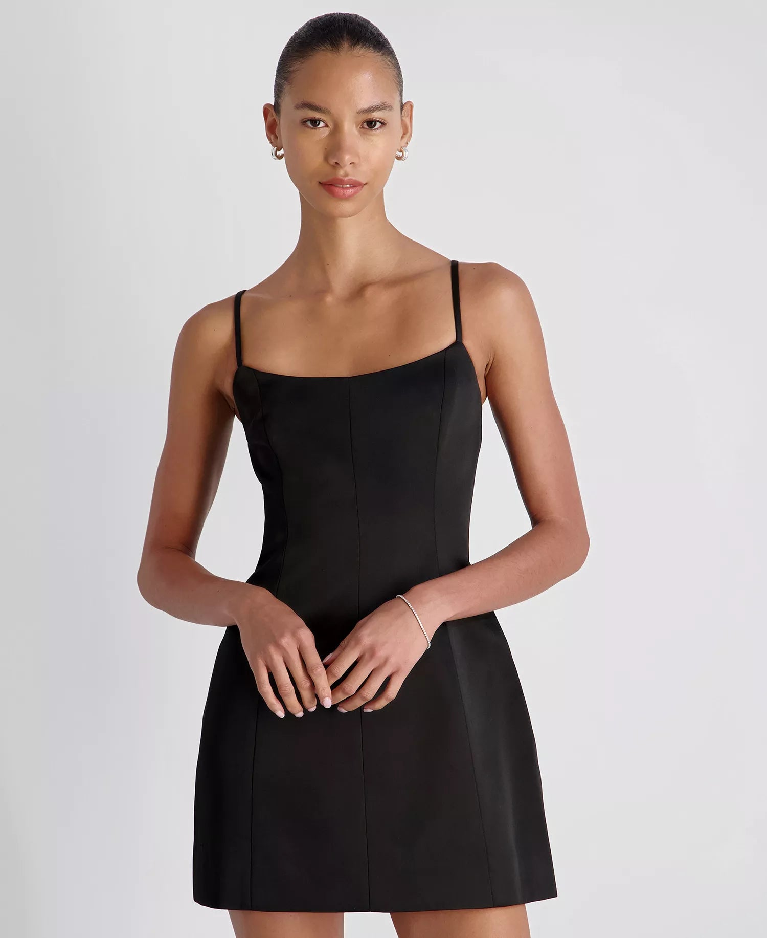 Woman wearing a black dress against a plain background