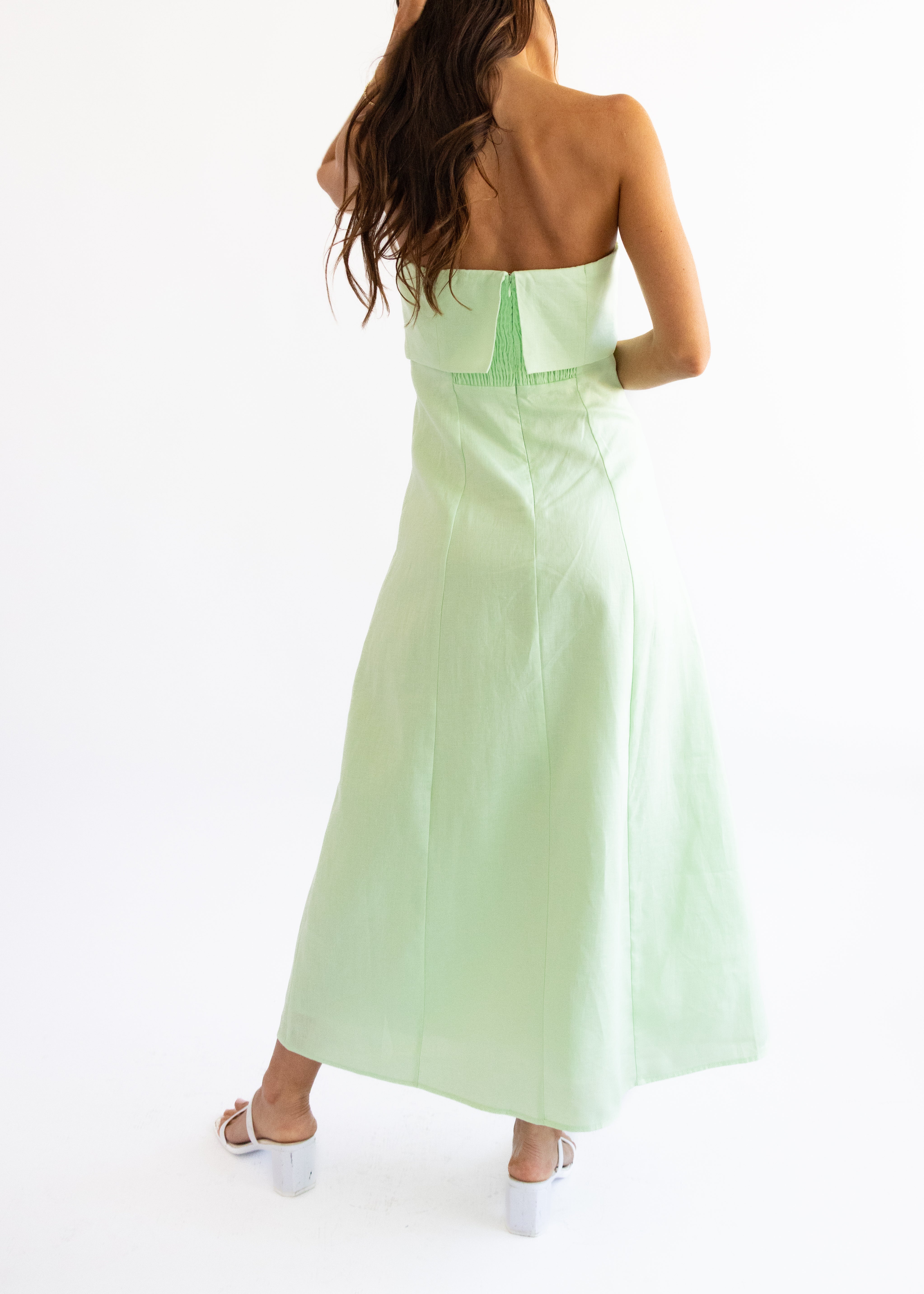 Light green strapless dress with floral embroidery on a white background