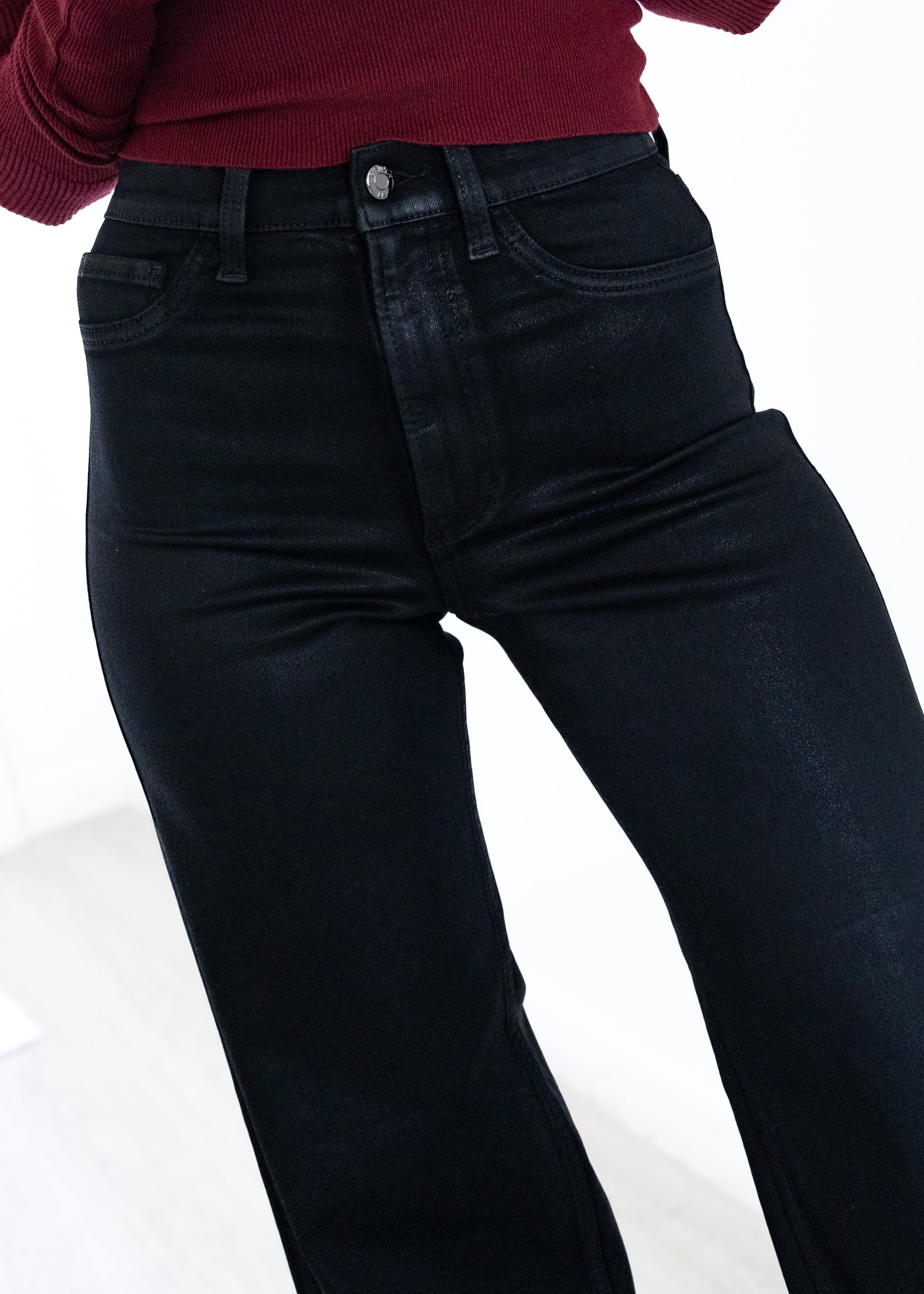 Person wearing black jeans on a white background