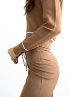 Brown knit outfit with white trim on a white background