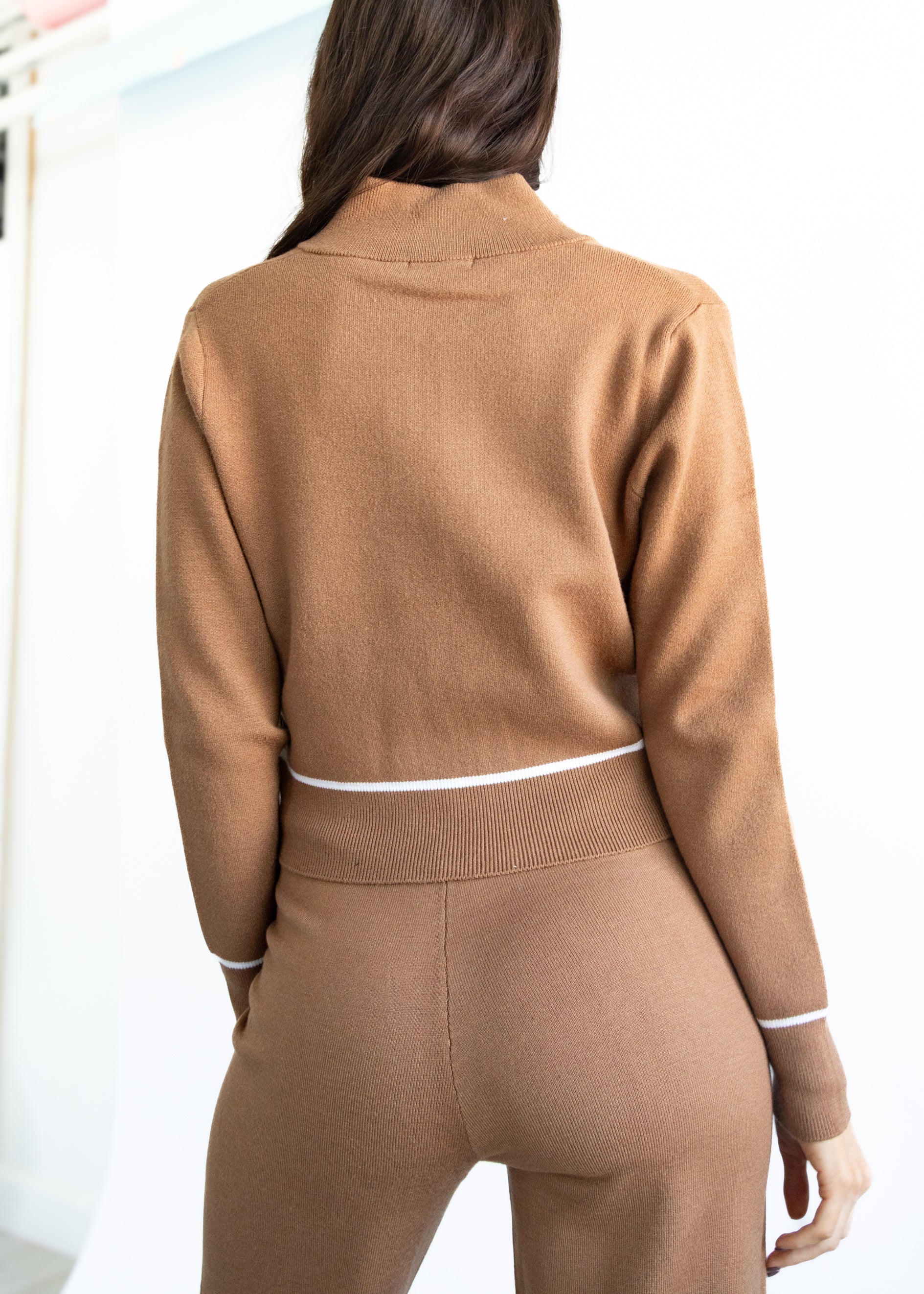 Brown tracksuit worn by a person on a white background