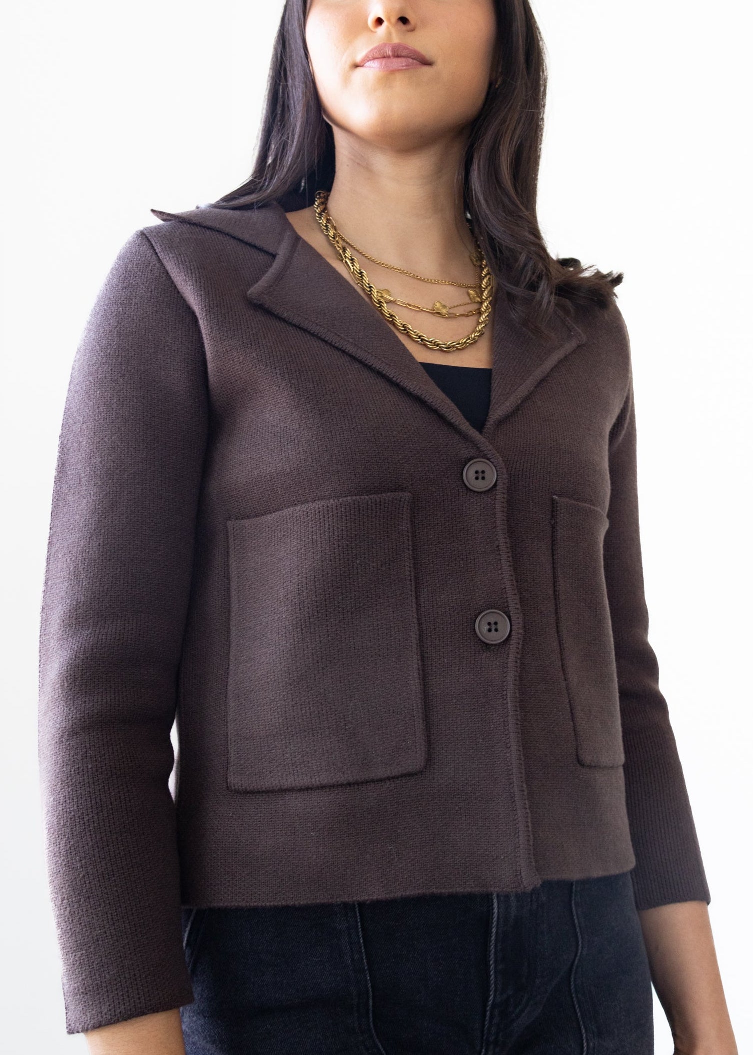 Woman wearing a brown jacket against a white background