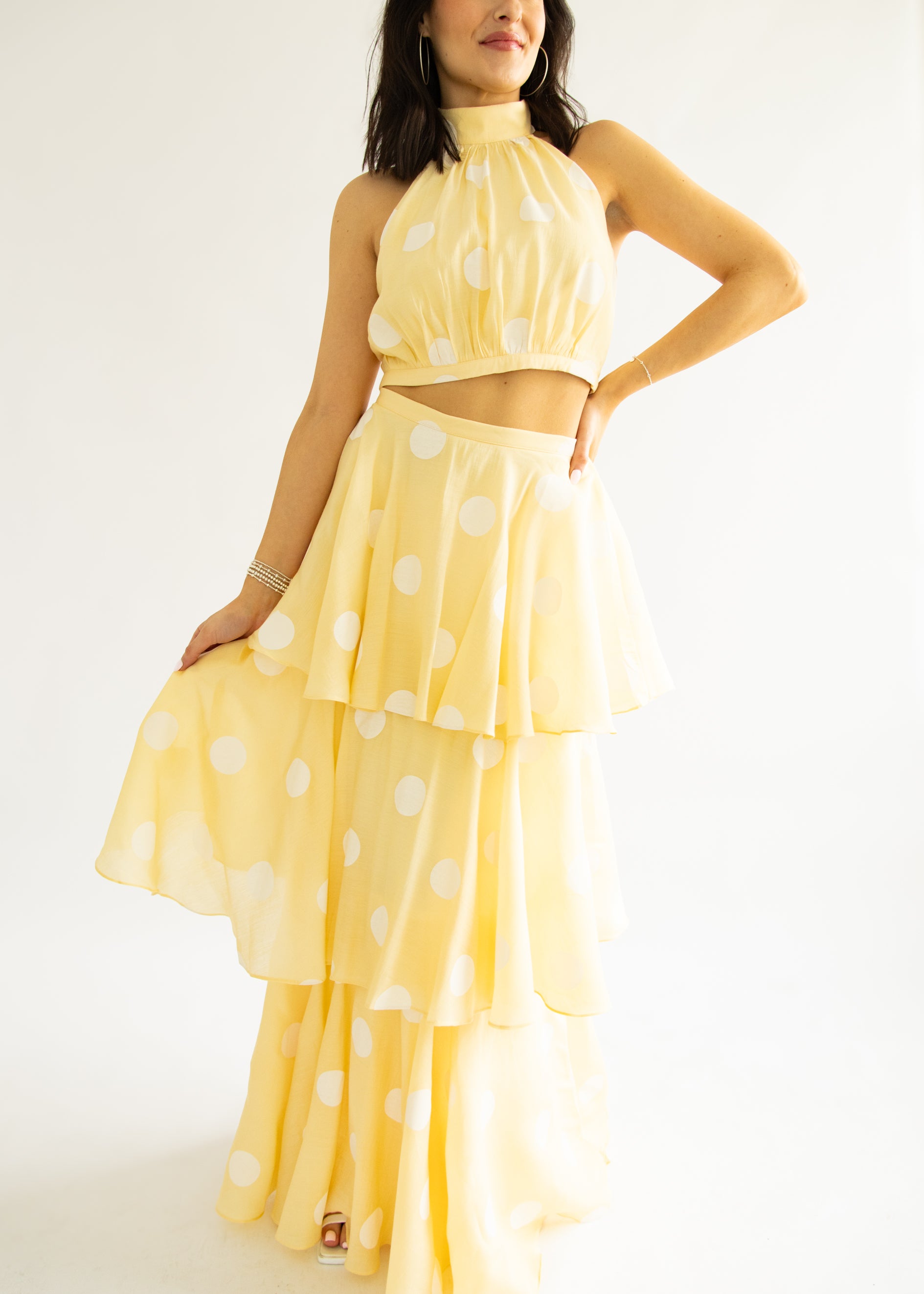 Woman wearing a yellow polka dot dress on a white background