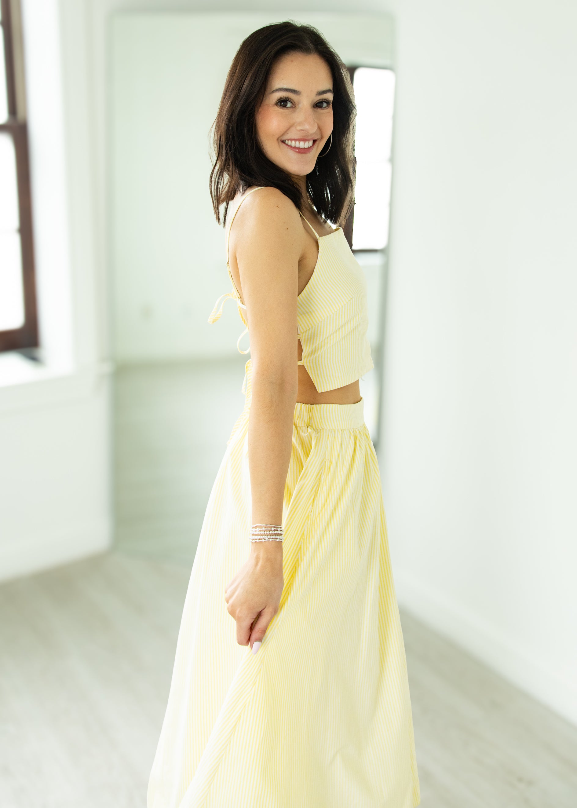 Woman wearing a light yellow dress in a bright room