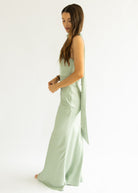 Woman wearing a light green dress with a white background