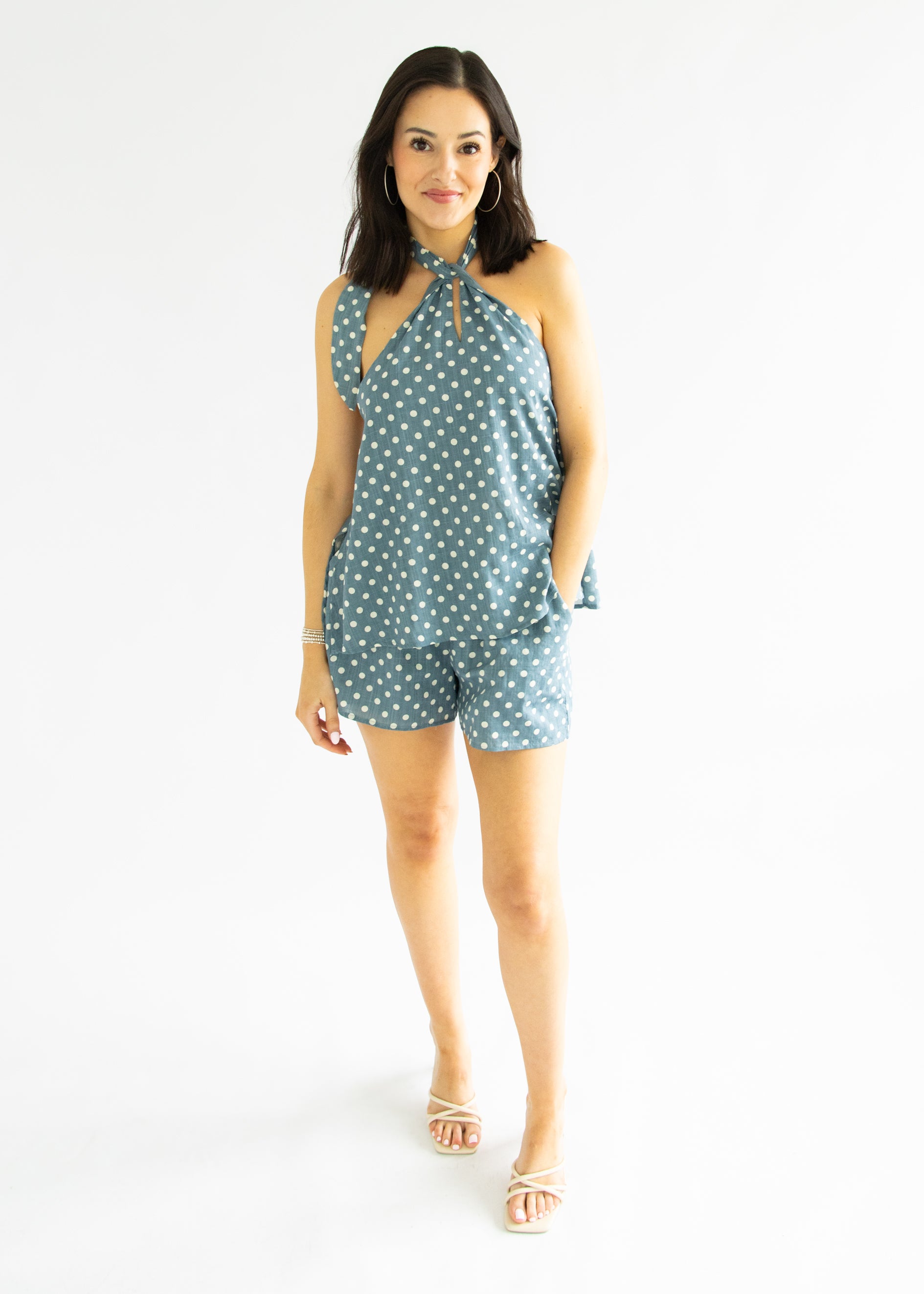 Woman wearing a polka dot romper on a white background