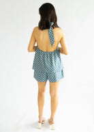 Woman wearing a polka dot romper on a white background