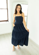 Woman wearing a navy blue dress in a bright room