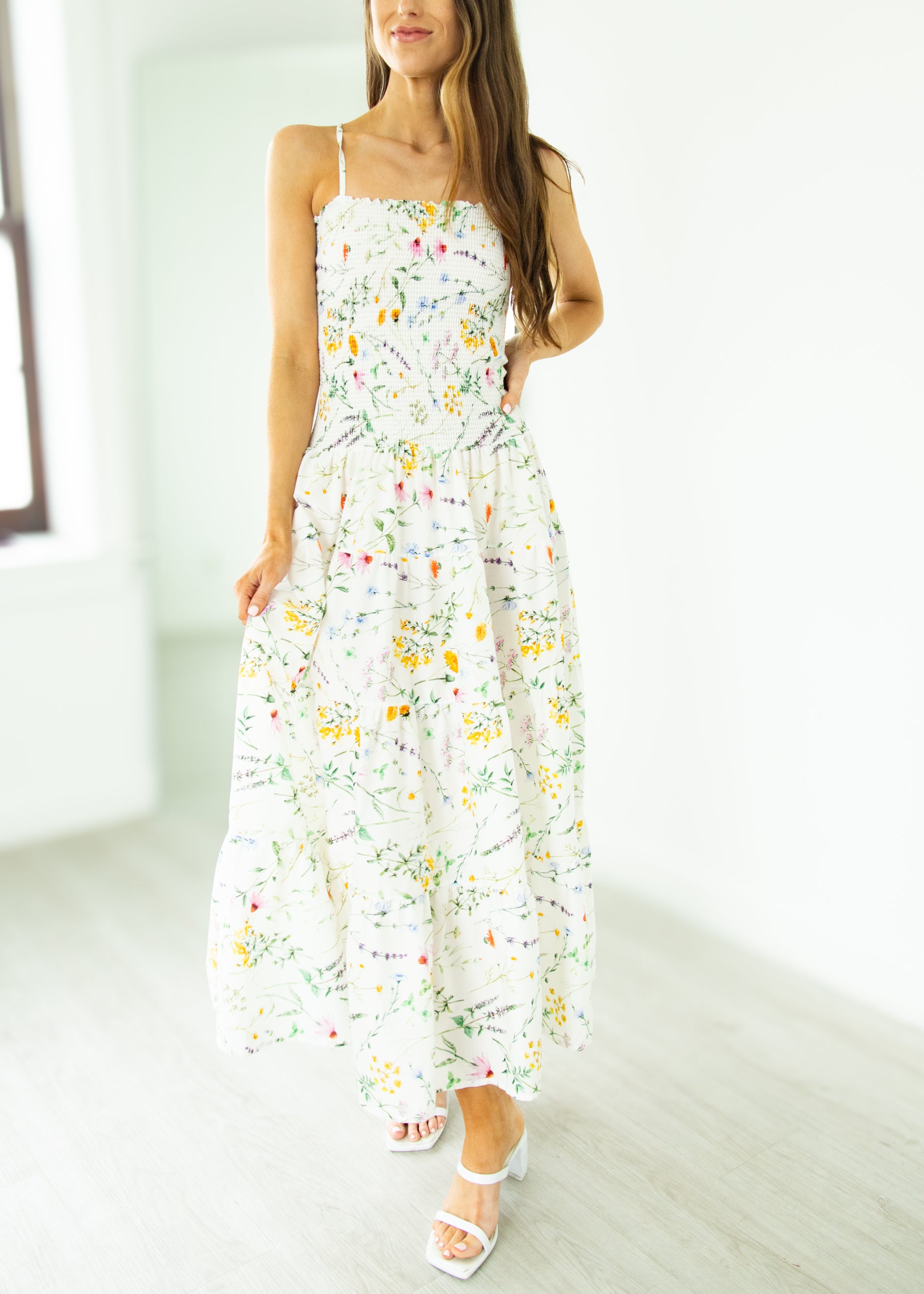 Woman wearing a floral dress in a minimal indoor setting