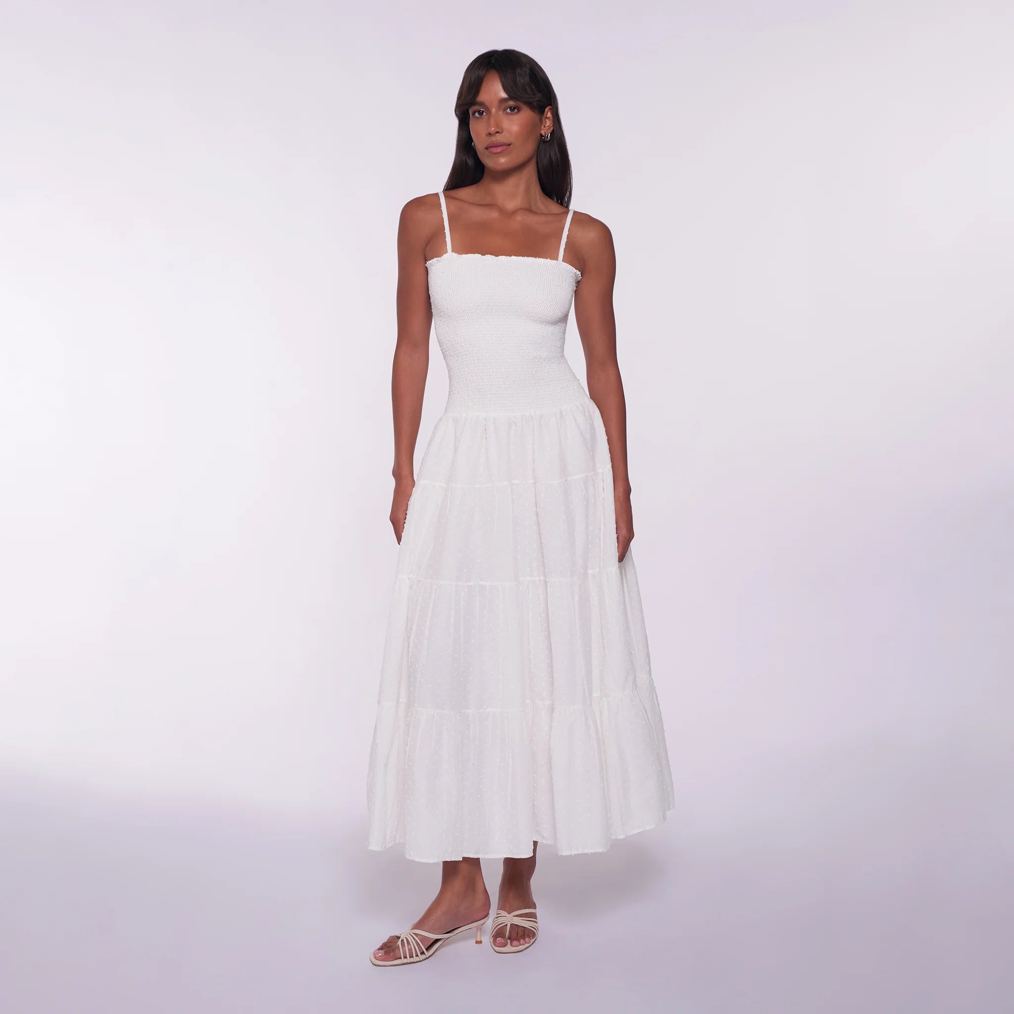 Woman wearing a white dress against a white background