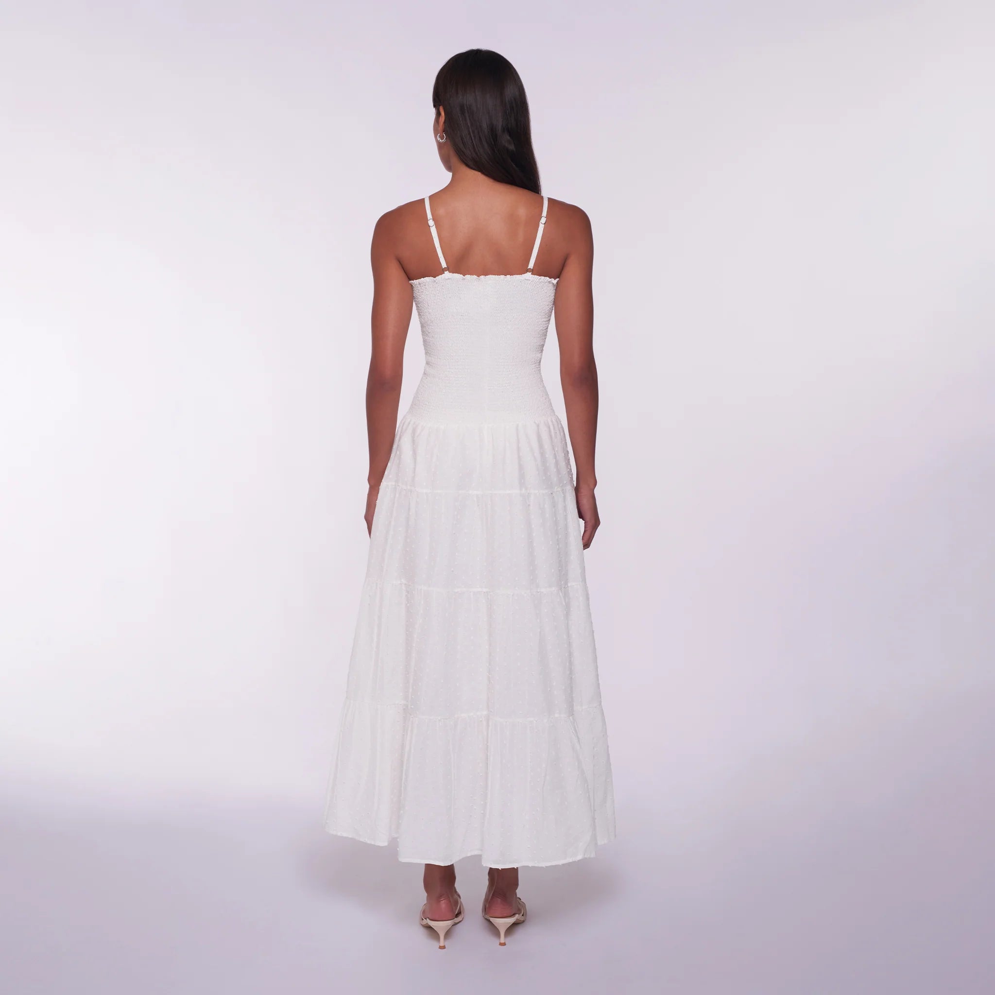 Woman wearing a white dress on a plain background