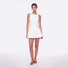 Woman wearing a white dress on a plain background