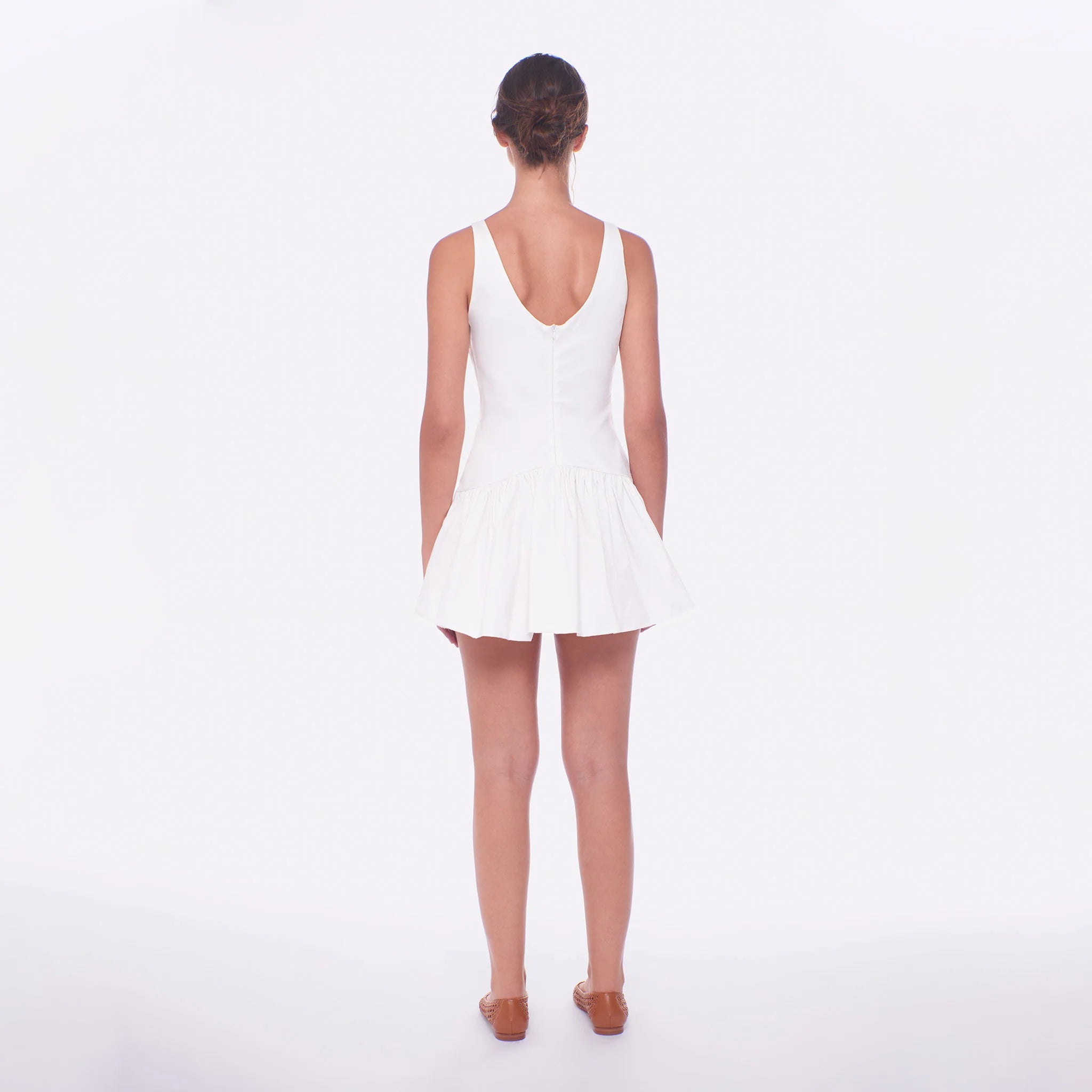 Woman wearing a white dress on a plain background