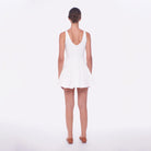 Woman wearing a white dress on a plain background