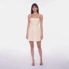 Woman wearing a beige dress with a white background