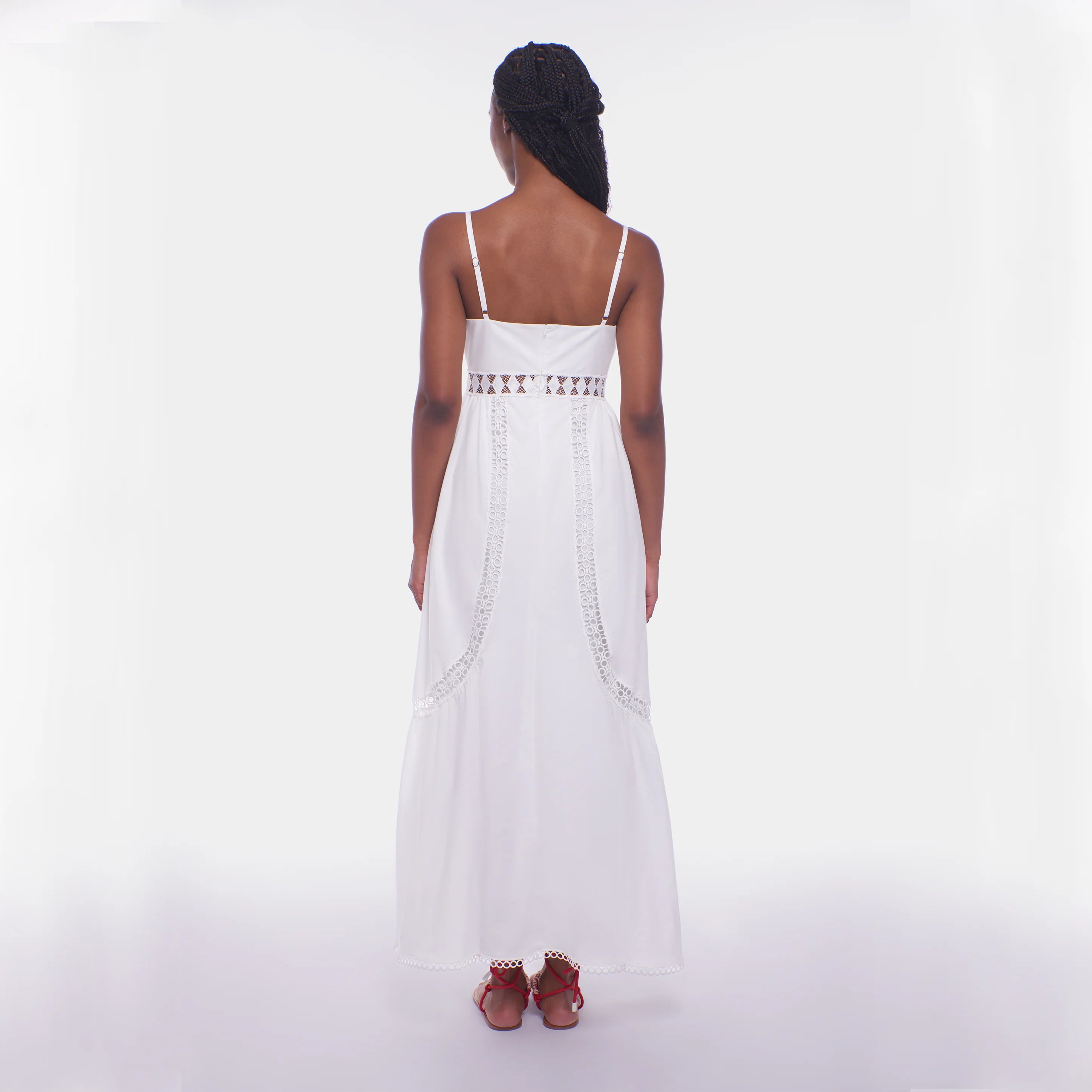 Woman wearing a white dress with thin straps on a white background