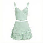 Light green two-piece set with a top and ruffled skirt on a white background