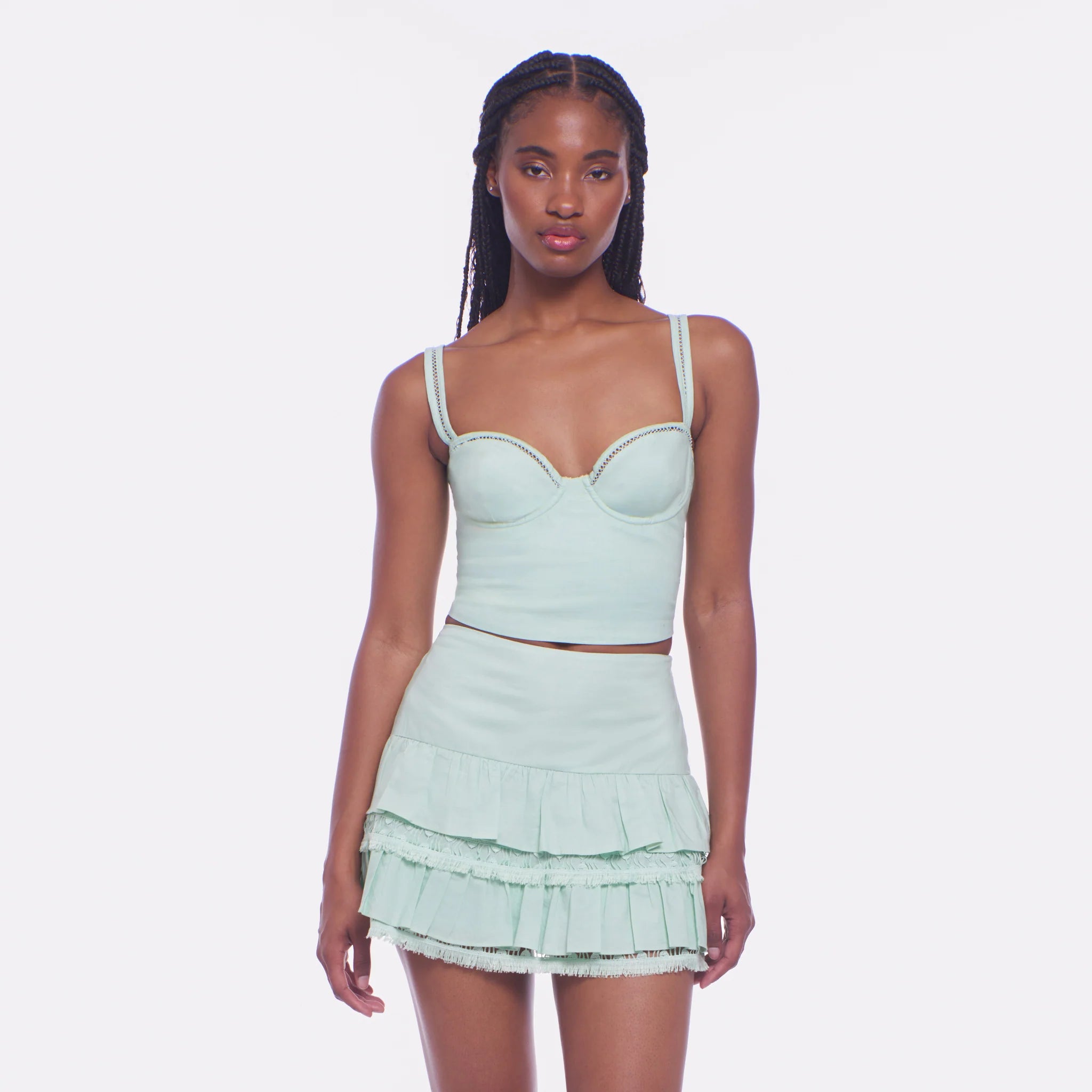 Woman wearing a light green two-piece outfit on a white background