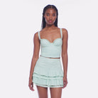 Woman wearing a light green two-piece outfit on a white background