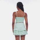 Woman wearing a light green dress with a plain background