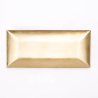 A rectangular gold tray with a brushed metallic finish, photographed from directly above on a clean white background.