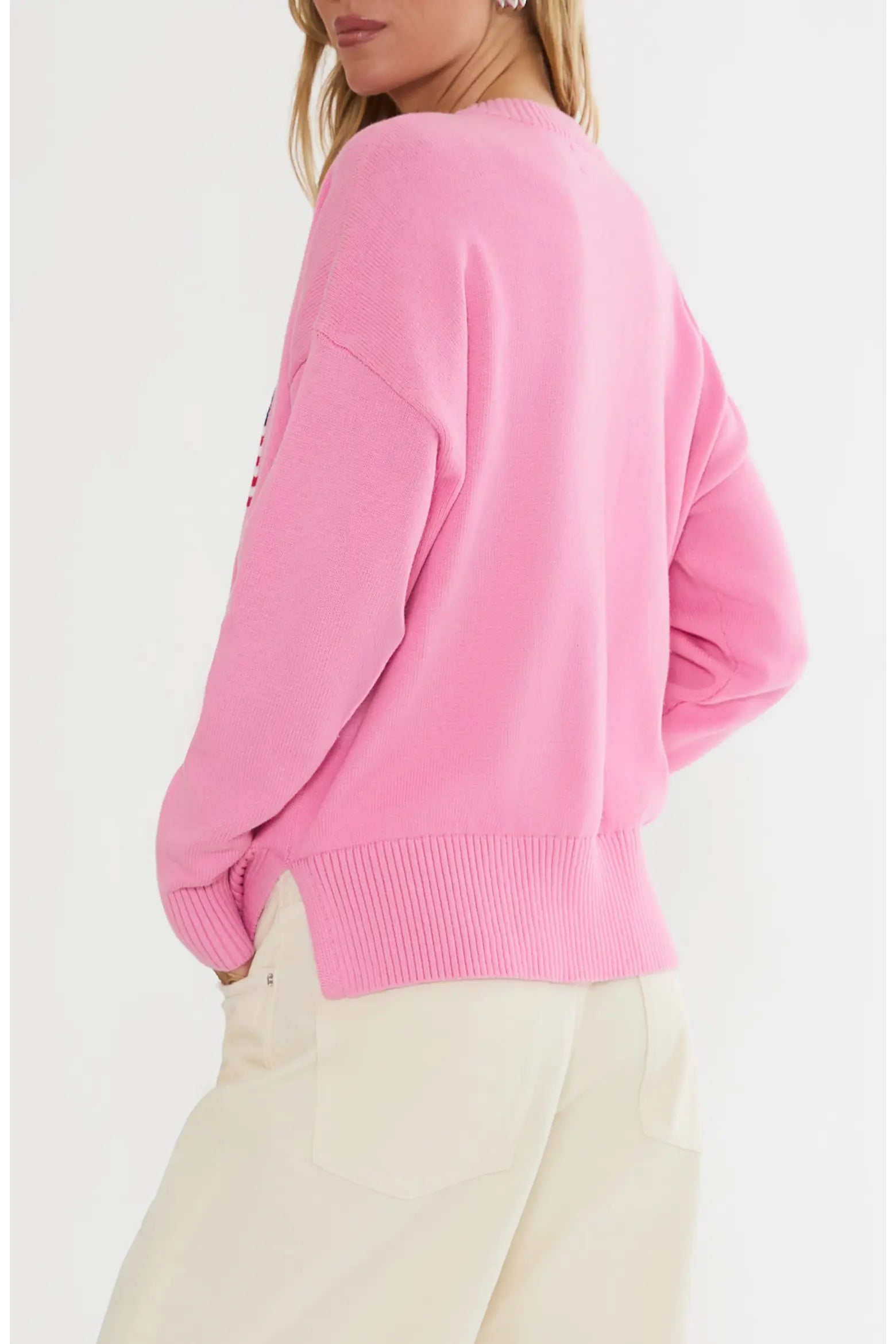 Pink sweater worn by a person on a light gray background