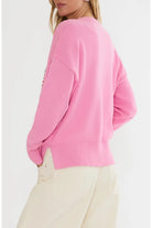 Pink sweater worn by a person on a light gray background