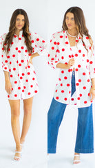 Two women wearing white polka dot cover-ups with red dots on a white background