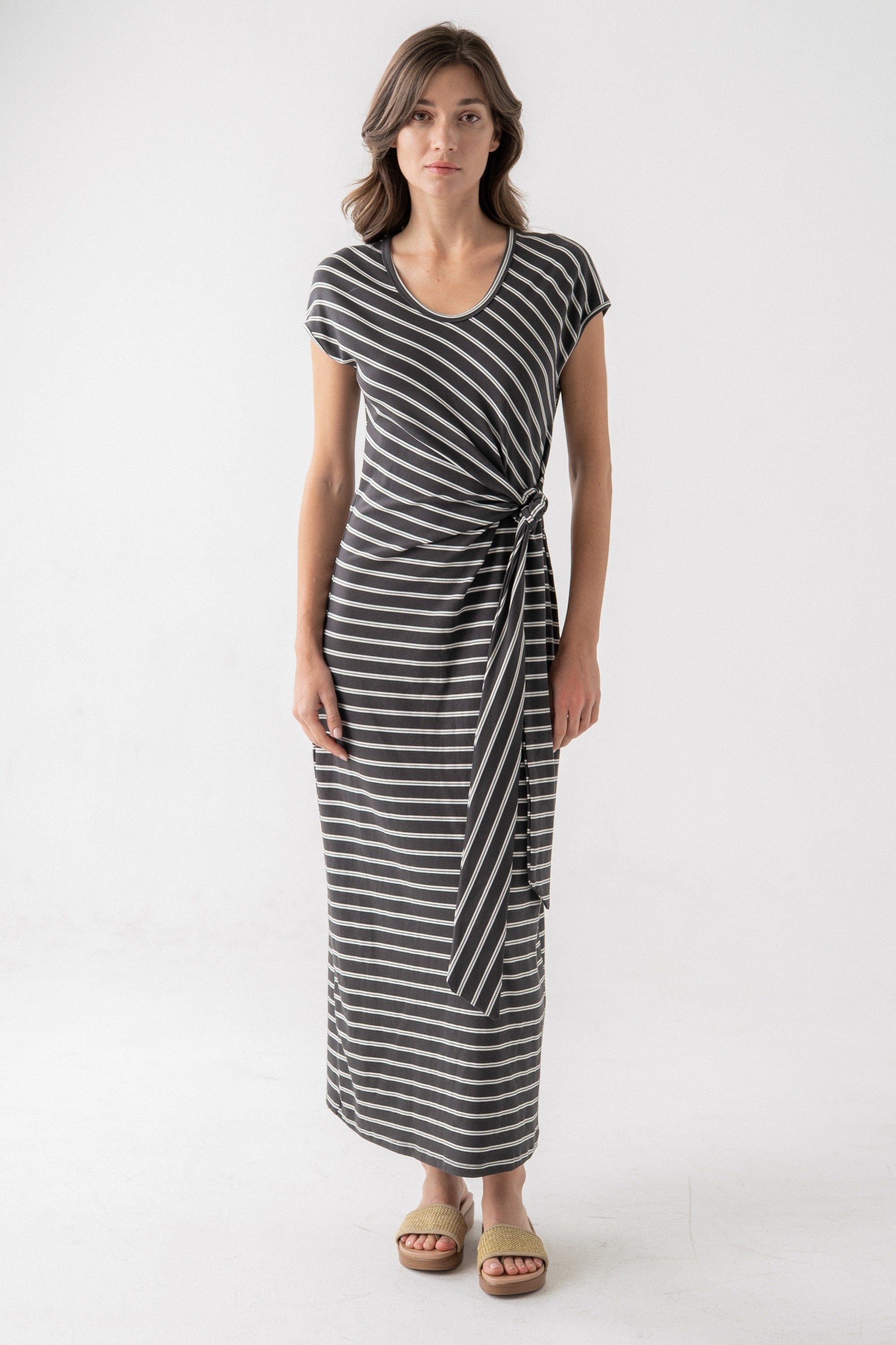 Woman wearing a black and white striped dress on a white background