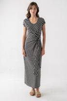 Woman wearing a black and white striped dress on a white background
