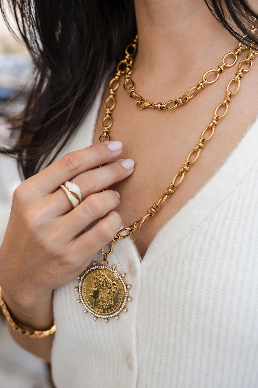 Gold chain necklace with a pendant worn by a person