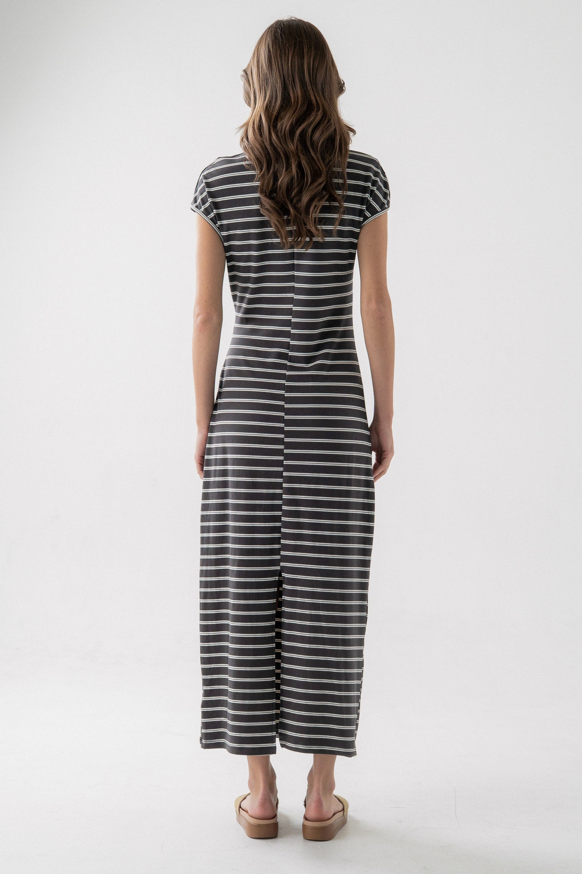 Woman wearing a black and white striped dress on a white background