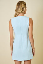 Light blue dress worn by a person on a beige background