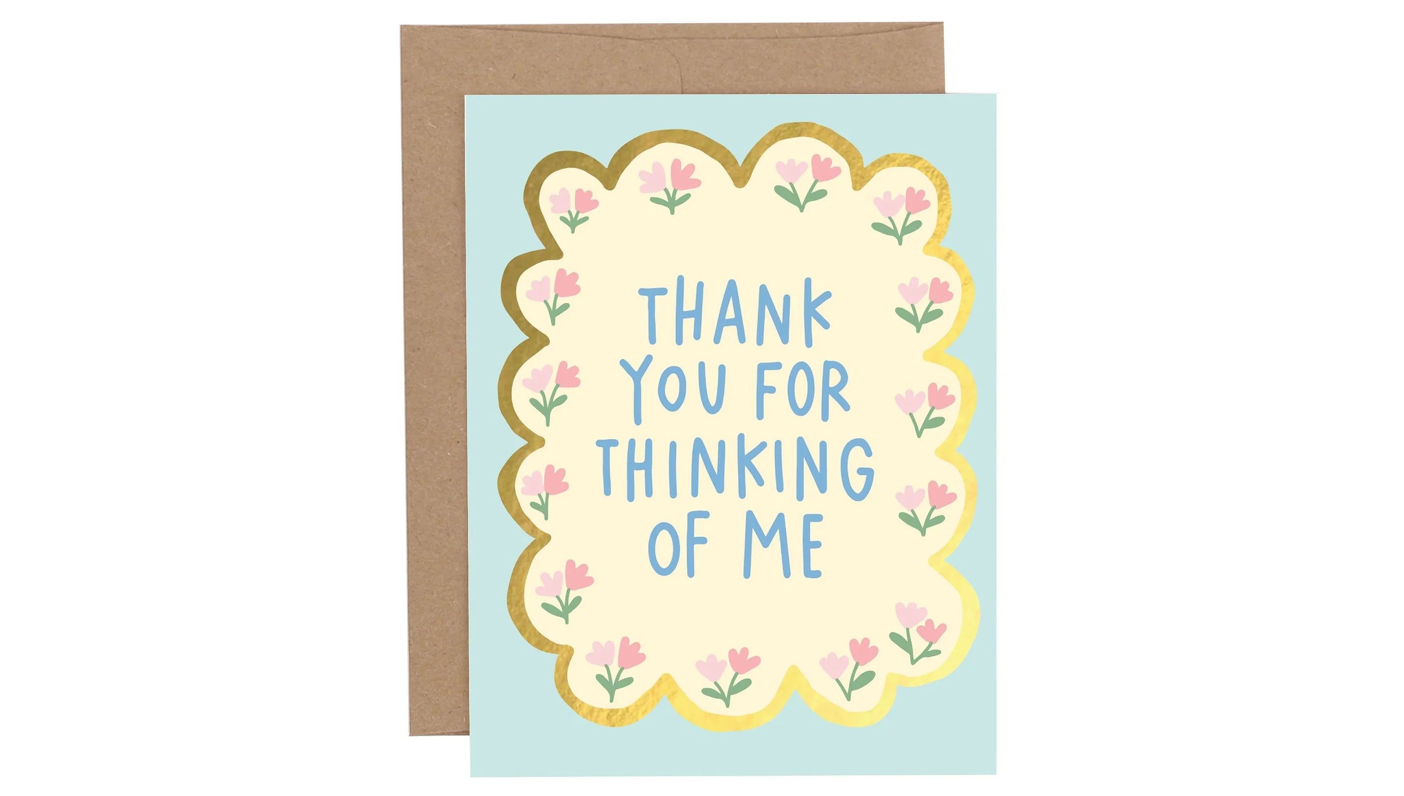 Greeting card with 'Thank you for thinking of me' text on a light blue background with floral design, next to a brown envelope.